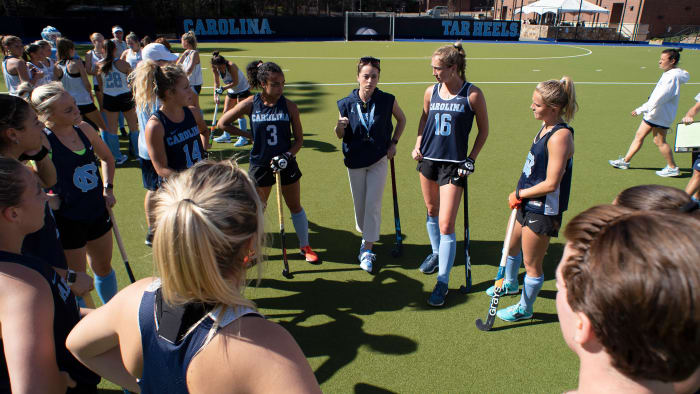 UNC field hockey coach Erin Matson stands in a circle with and speaks to her players at practice.